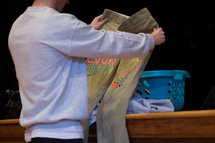 1st-year apparel design student, Alexander Hill, prepares his designs for the runway. 
