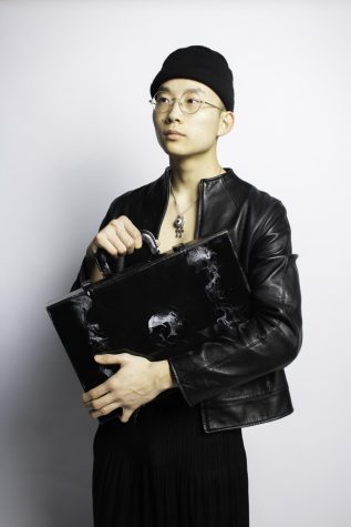 Person in a all black outfit holding a black briefcase style bag.