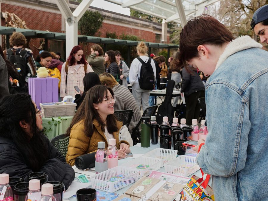 Trinity Farr (she/they) sits at her booth at the SOL flea market on Wednesday, March 1 on the Oregon State Corvallis campus. Trinity was selling her artwork in the form of stickers, as well as pet portraits and she filled her commissions list at the event. 