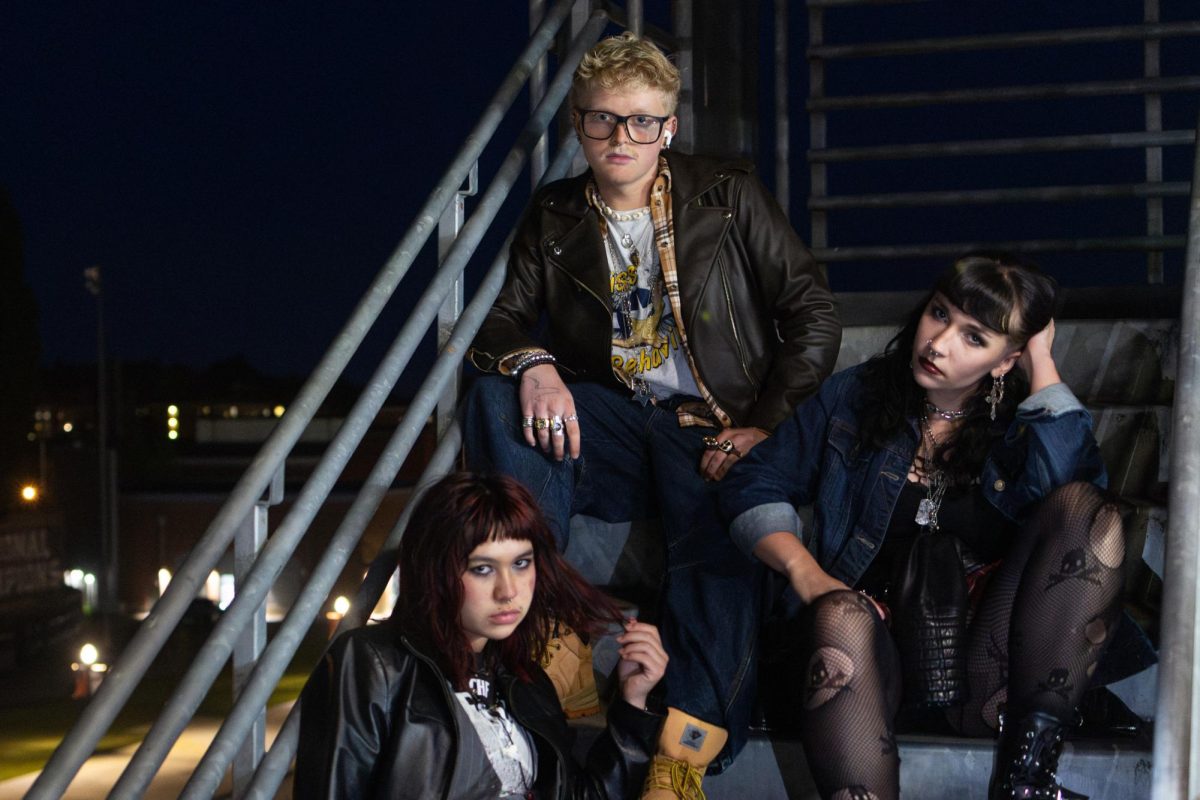 Three people sit on a staircase